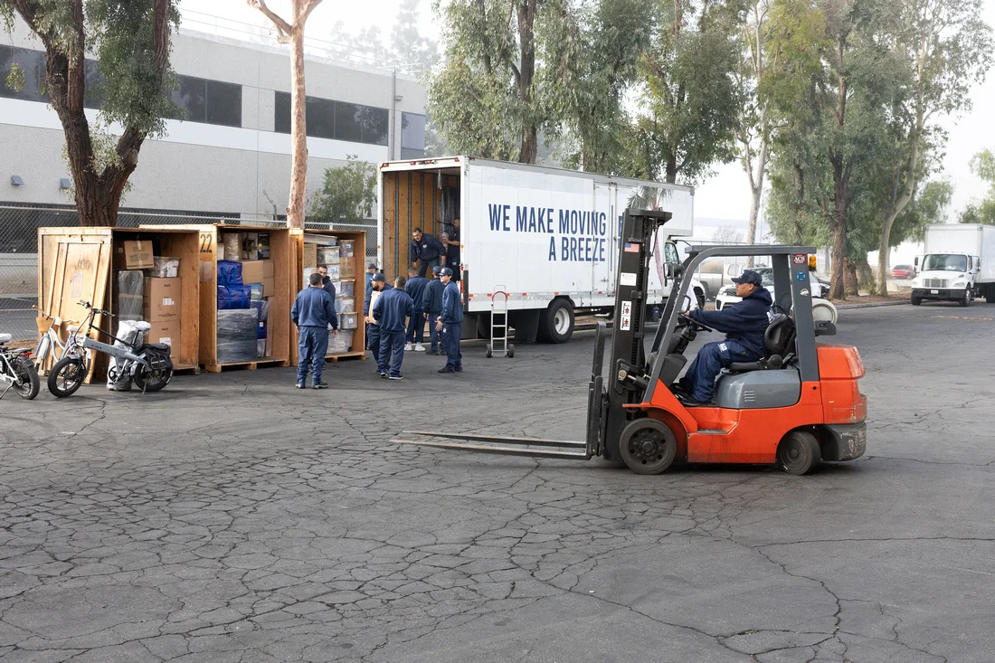 BLVD crew staging storage crates with a forklift and moving truck