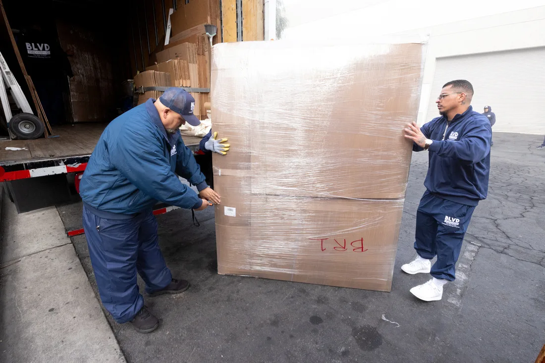 BLVD movers protecting furniture with moving pads