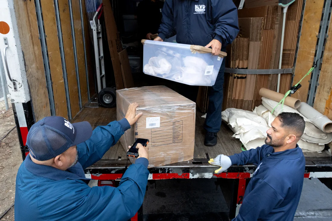 BLVD movers loading organized cartons into a moving truck